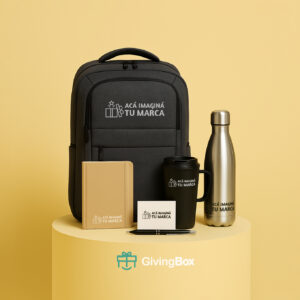 Kit de bienvenida premium con mochila, taza térmica, botella metálica, cuaderno de tapa dura, lapicera de lujo y tarjeta, sobre fondo amarillo