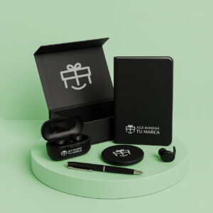 Set ejecutivo con auriculares, libreta, lapicera, cargador inalámbrico y caja imantada negra sobre pedestal verde.